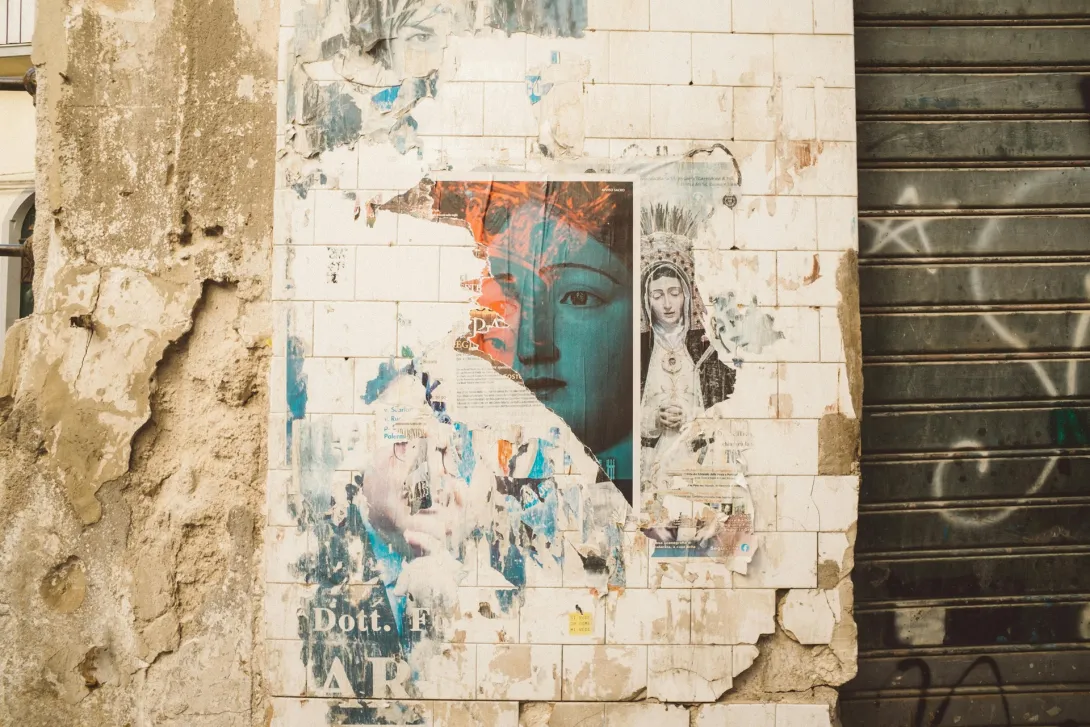 Un muro con degli affissi diversi e strappati.